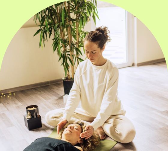 A practitioner resting her hands near a client's head during an energy session